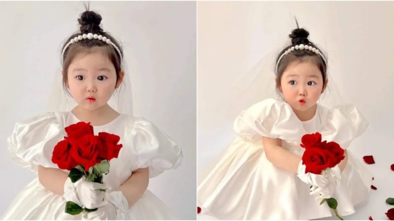 Enchanting Elegance: A Young Girl Radiates Pure Innocence in a Delicate White Dress.